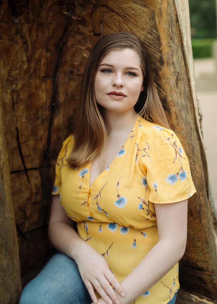 Relaxed outdoor portrait of a woman gazing from a wooden seat in Jephson Gardens, Leamington Spa.