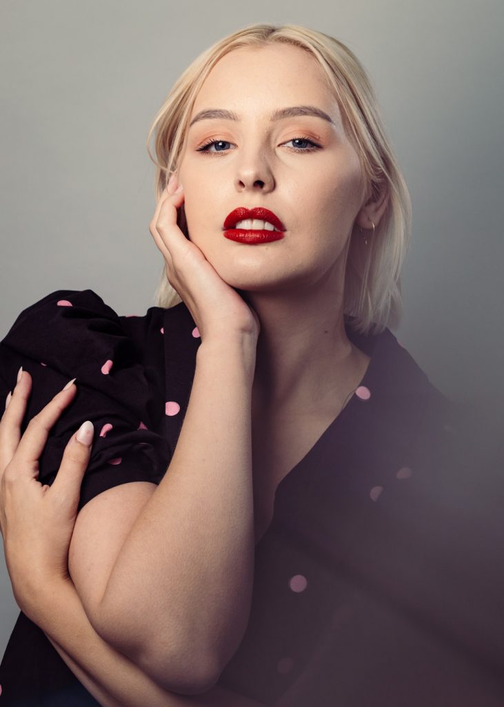 Model in a sexy studio pose wearing a polka‑dot shirt, contemporary style